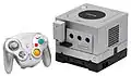 A silver GameCube with optional Game Boy Player and Wireless Controller installed.
