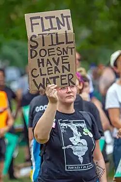 A Flint protestor in 2019. Issues with the Flint water supply persist.