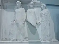 White relief of three robed Charites