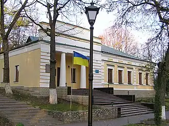 One-storey building with yellow walls and two columns at the entrance