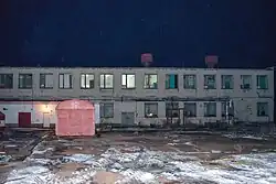 A disused two-story structure, extending out of frame to either side.