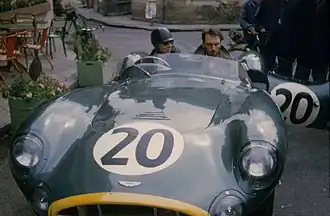 Tony Brooks (driving) in his Aston Martin DBR1 at the Hotel de France just before the race.