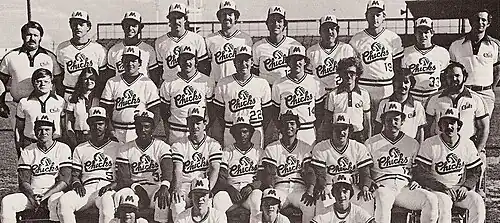 A black and white photograph of baseball players in uniforms posed in three rows on a baseball field