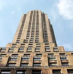 Detail of the facade looking up from ground level. There are spandrels and other decorations above the windows, as well as vertical piers separating each bay of windows.