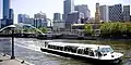 A flat boat is seen cruising along the Yarra River in Melbourne, Australia