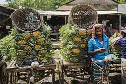 A pineapple vendor at Jalchatra Bazar in Modhupur, Tangail, surrounded by his vibrant, fresh produce.
