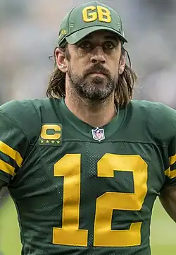 Rodgers in a Packers uniform wearing a hat.