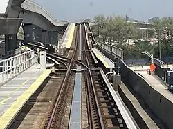 View of a track switch north of the Federal Circle station, with a track going straight and another diverging to the left. The track continuing straight goes to Jamaica, while the track diverging to the left goes to Howard Beach.