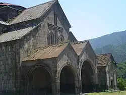 Gabled roof with extensions over a covered entrance with two gabled arches.