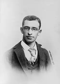 A 22-year-old man wearing an ill-fitting necktie, suit, and vest