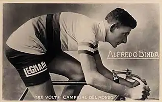 A man in a white top with a hat on standing in front of two people