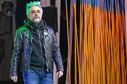 A middle-aged man in a leather jacket and jeans