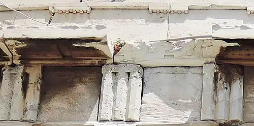 Marble triglyphs, closely zoomed in: Greek letters can be seen carved above.