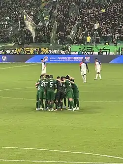 Players gathering in the match against Shanghai Shenhua