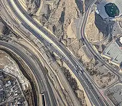 This aerial view of the Mexico–US border near the Sun Bowl stadium in El Paso, Texas, shows the state of construction of the Border West Expressway crossing above the railroad tracks (center), in December 2017. The neighborhood at the lower left is in Ciudad Juárez, Chihuahua, Mexico.