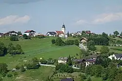 Blue clear sky, houses on a grass field.