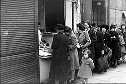 Street scene of people queueing outside a shop