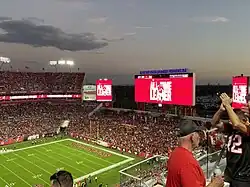 Picture of the inside of a football stadium. The jumbotron says "All-Time Leader" and shows an image of Tom Brady. The Buccaneers lead the Bills 24-3.