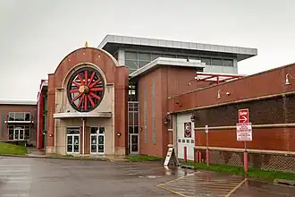 Brick building with automobile wheel motif over main entrance