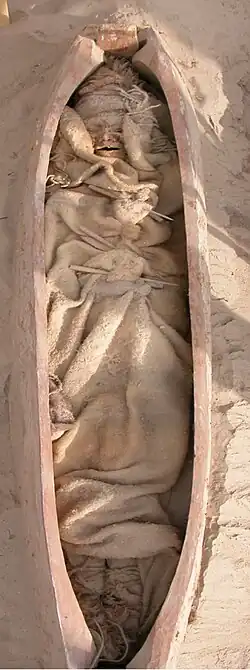 Burial XHM66 from Xiaohe cemetery, with boat-shaped coffin and mummified remains dressed in woollen garments