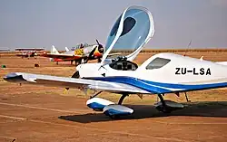 A white plane at the airport, with another visible in the background