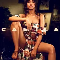 The cover image features Camila Cabello in foreground sitting on a small circular table wearing nature themed bra-like crop-top and long-skirt. In the background is a dim-lighted living-room. Above everything, in the middle, spread over whole width, in capitalized and bold format, is written the title 'CAMILA'.