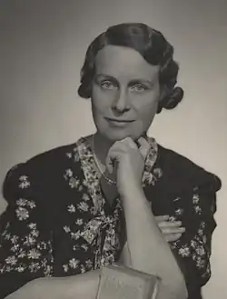 Black and white portrait photograph of Haslett taken about 1925. She is looking into the camera, wearing a dress and resting her chin on her hand. Electrical Association for Women