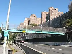 Pedestrian bridge over the parkway to the Hudson River Greenway, north of the Plaza, as seen from the Greenway; in the background is the Castle Village complex.
