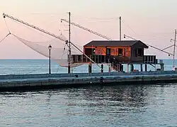 house on a pier, with large nets hanging from long poles