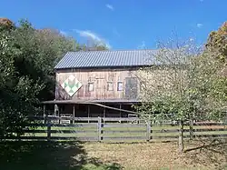 A barn has a stylized chalice painted on side facing Route 643