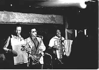 Chenier Brothers performing at Jay's Lounge and Cockpit, Cankton, Louisiana, Mardi Gras, 1975 Clifton Chenier on accordion, brother Cleveland on washboard and John Hart on tenor saxophone.