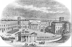 An elevated view of four neoclassical buildings, the main block, two side blocks and a gateway