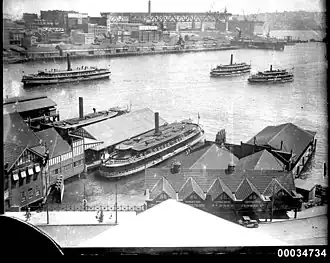 Koree, foreground, at Circular Quay with other K-class ferries with the Sydney Harbour Bridge under construction behind, during Sydney Ferries Limited's 1920s peak