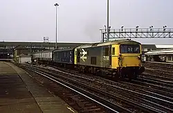 A British Rail Class 73 with a parcels van and carriages under British Rail carrying the mail in 1986 through Clapham Junction
