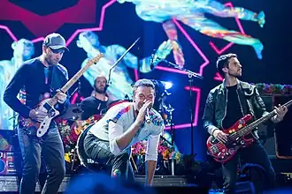 Coldplay onstage with their respective instruments