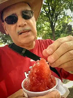 Man eating a piragua (Puerto Rican shaved ice) in Paseo de la Princesa in 2014