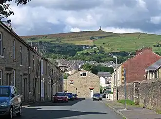 view of a street in a small town with the moors rising high in the distance, crowned by the tower