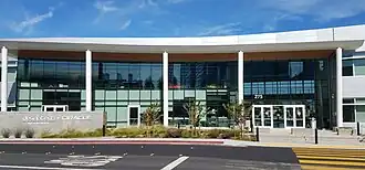 A colonnade with glass doors and a sign for Design Tech High School
