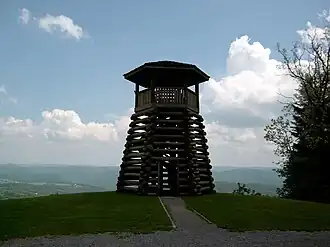 A wooden observation tower overlooking a forested valley.