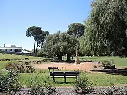 Photograph of a tall war memorial and benches
