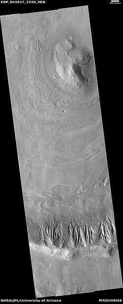 Wide view of dipping layers in Ismenius Lacus quadrangle, as seen by HiRISE under HiWish program. Gullies are also visible at the bottom of the image.