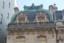 The house's mansard roof, which contains two windows and is made of slate and copper
