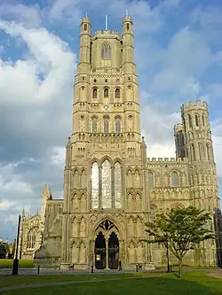 Ely Cathedral, England, the central western tower and framing smaller towers all had transitional features, 1180s. The tower to the left fell. Gothic porch, 1250s; lantern, 1390s.