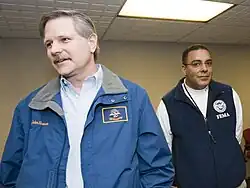 Gov. John Hoeven (2000–2010) wears a North Dakota State Flag patch on his jacket at a press conference in Fargo.