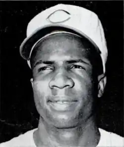 A head shot of an African-American man with a white baseball cap with a red "C" in the center.