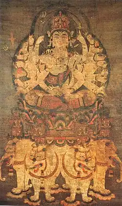 Deity with many arms seated on a pedestal on top of four white elephants.