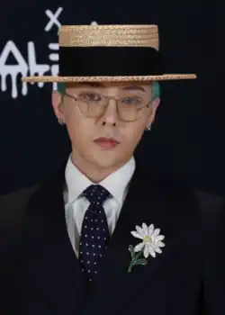 G-Dragon wearing a suit and looking at the camera