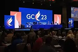 Group of people in a business meeting. GC23 logo on digital background blue screen.