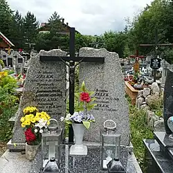 Granite gravestone decorated by a black crucifix