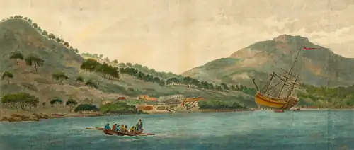 A large wooden ship, resting on its side on a beach